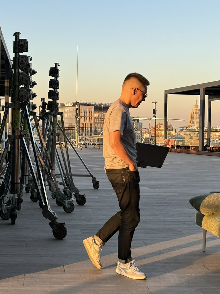 A colleague carrying a laptop across a rooftop at sunset